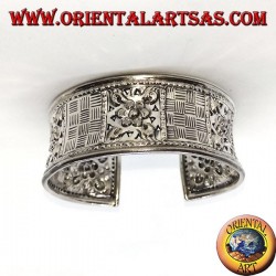 Pulsera de plata ancha cincelada a mano con motivos florales cuadrados.