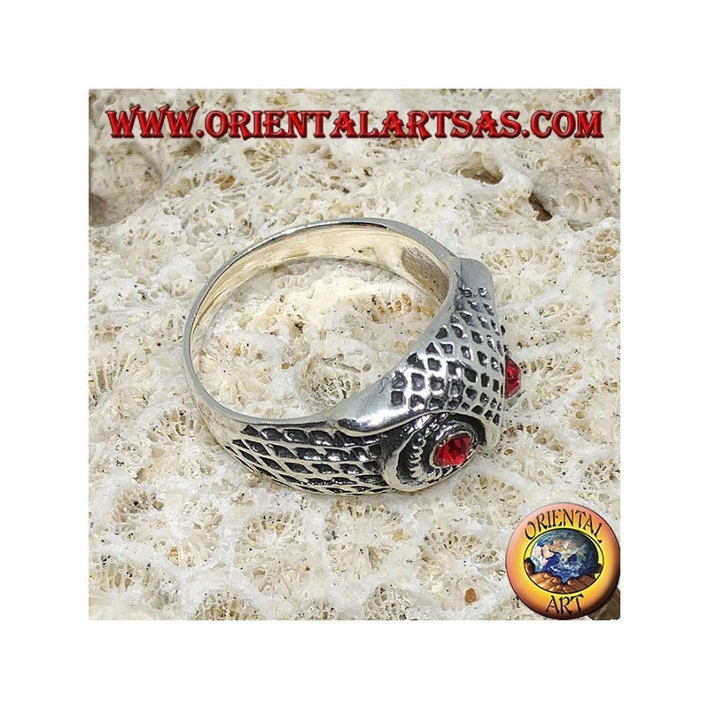 Anillo de plata con cabeza de lechuza y ojos rojos.