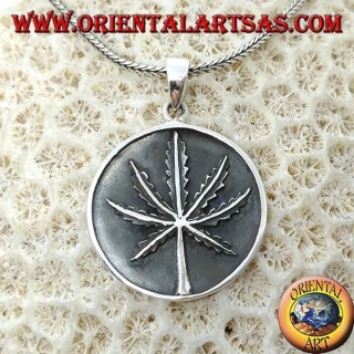 Medallón de plata con hoja de marihuana de bajo relieve.