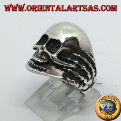 Anillo en plata con calavera en las manos.