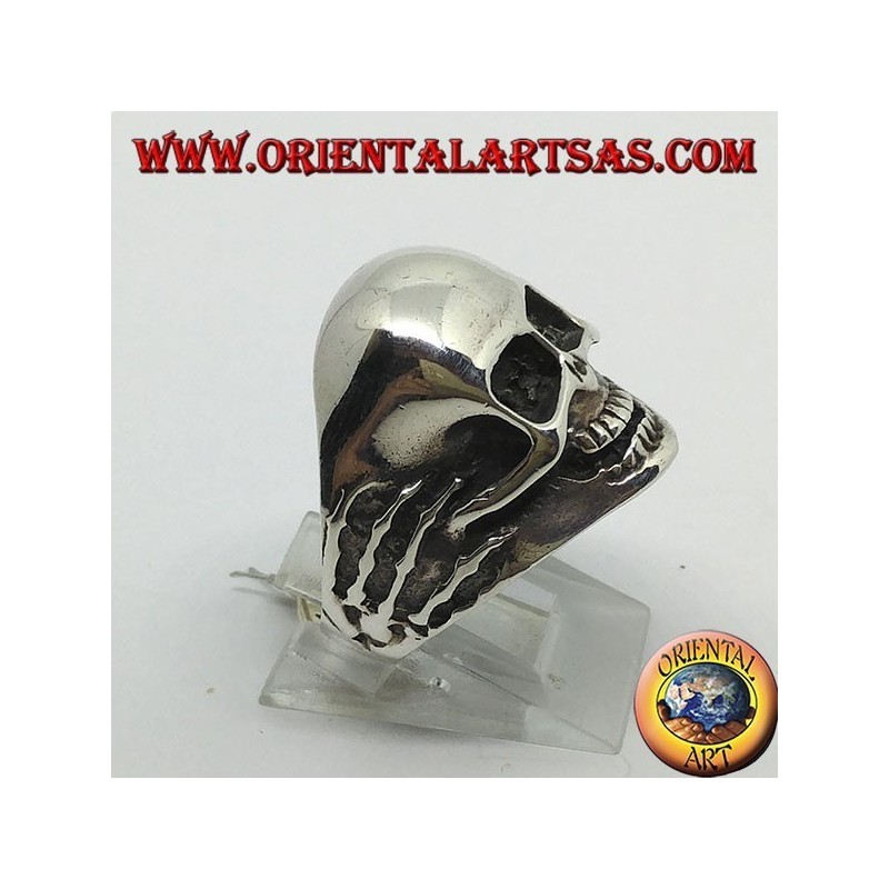 Anello in argento teschio tra le mani