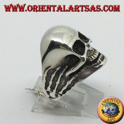 Anillo en plata con calavera en las manos.