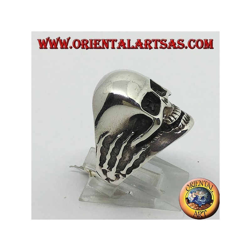 Ring in silver skull in hands