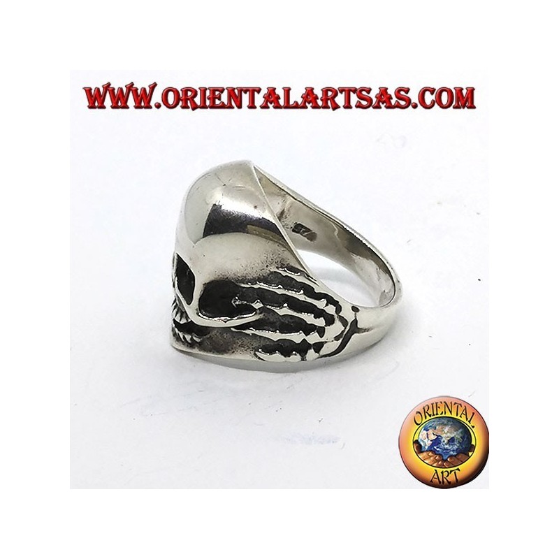 Bague crâne en argent dans les mains