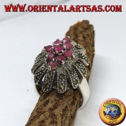 Anillo de plata en flor con siete rubíes conjunto rodeado de marcasitas.