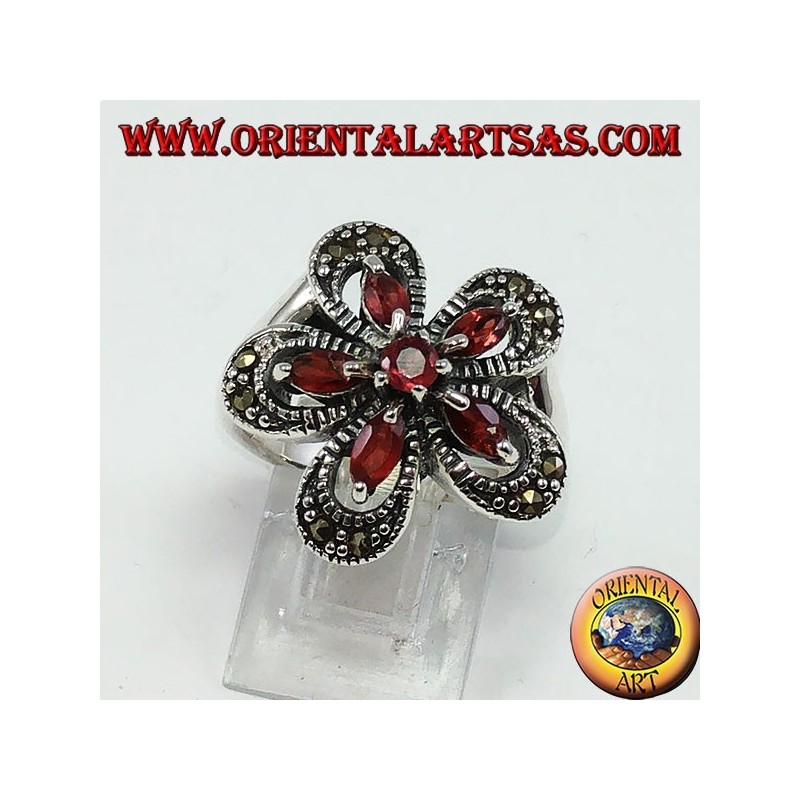 Anillo de plata con forma de flor con 5 granates lanzadera y una ronda central.