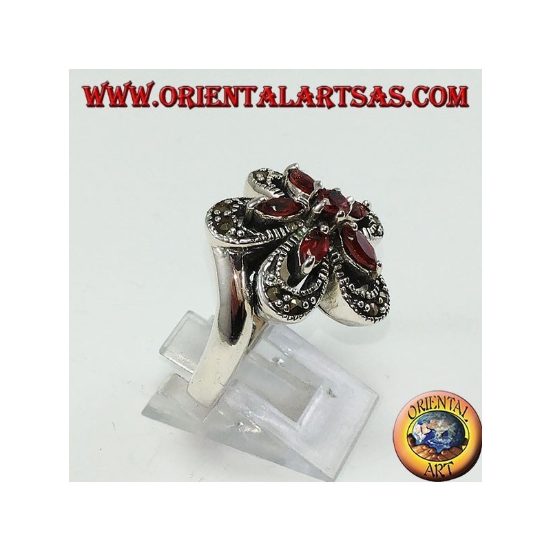 Silver ring in the shape of a flower with 5 shuttle garnets and a central round