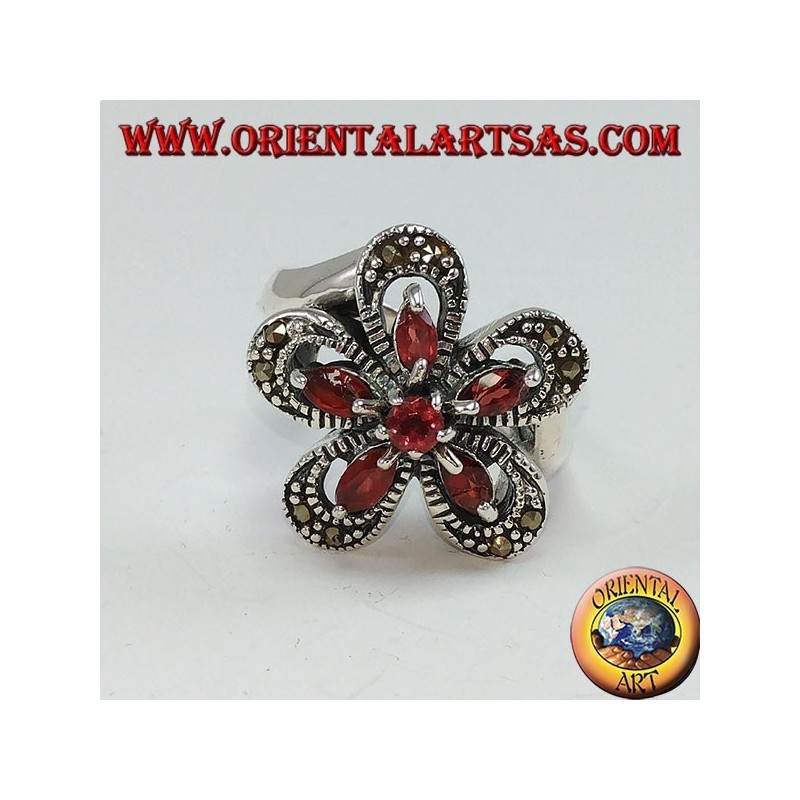 Anillo de plata con forma de flor con 5 granates lanzadera y una ronda central.