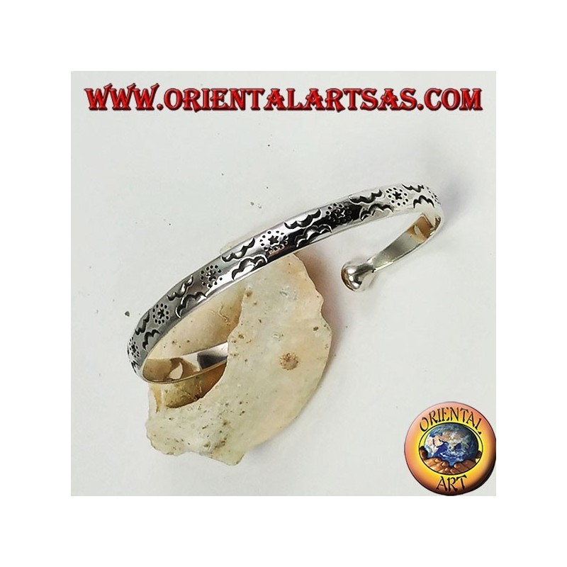 Pulsera rígida en plata, con estrellas y nubes grabadas a mano.