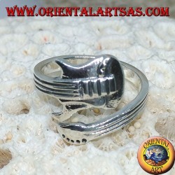 Anillo de plata envolviendo guitarra eléctrica, horizontalmente.