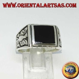 Anillo de plata con ónix rectangular y águilas en bajorrelieve en ambos lados.