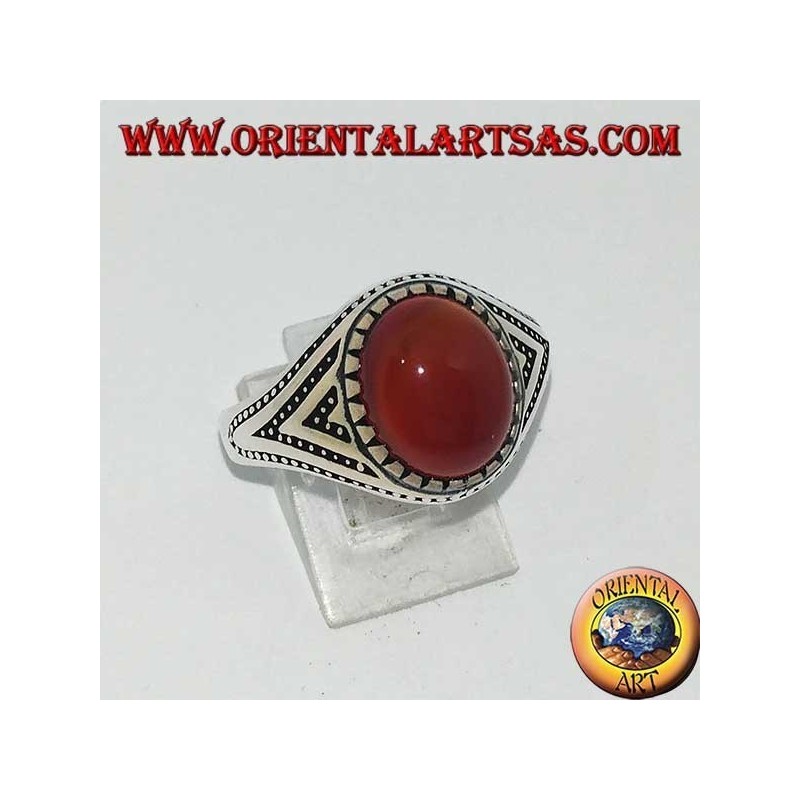 Anillo de plata con cornalina ovalada engastada con triángulos y decoraciones de puntos laterales.