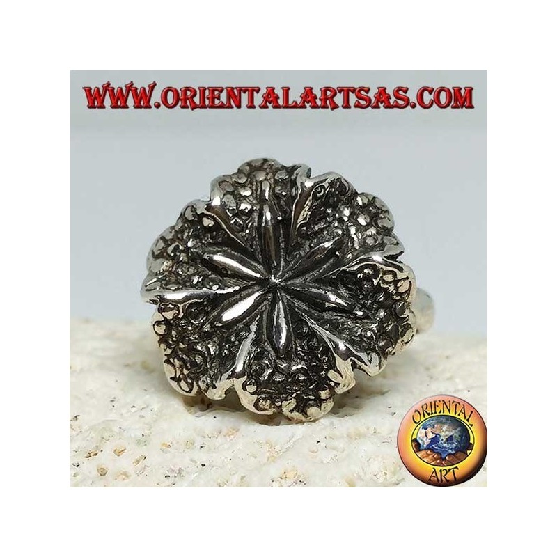 Anillo de plata con forma de flor de lirio, símbolo de pureza.
