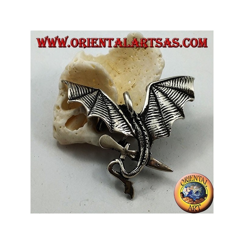 Pendentif dragon en argent avec ailes déployées et poignard entre les griffes