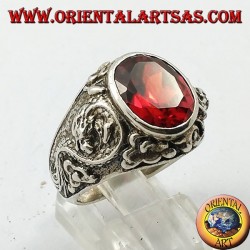 Silver ring with oval faceted garnet and stylized dragon in high relief on the sides