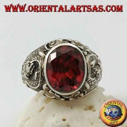 Silver ring with oval faceted garnet and stylized dragon in high relief on the sides