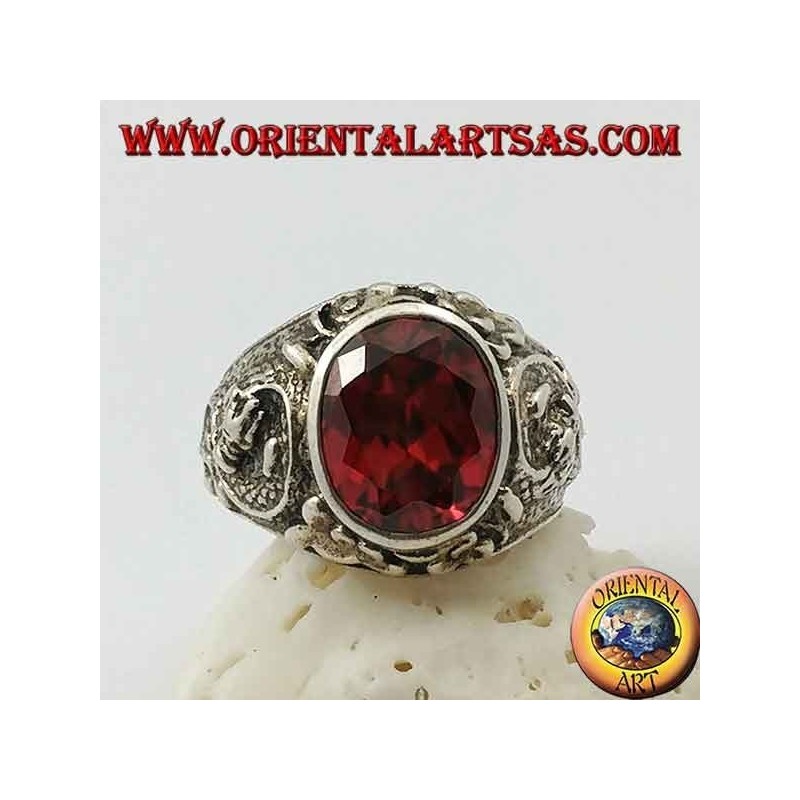 Silver ring with oval faceted garnet and stylized dragon in high relief on the sides