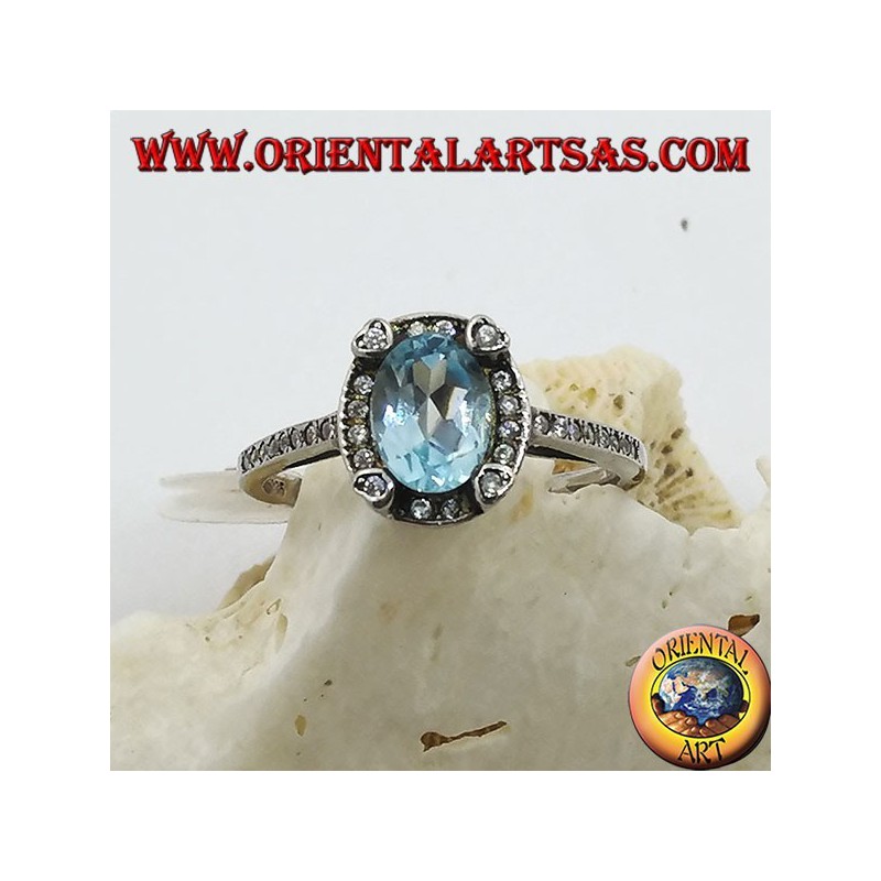 Silver ring with natural oval blue topaz set surrounded by zircons