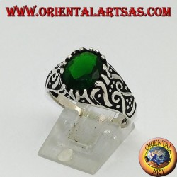 Silver ring with oval emerald zircon and high relief decorations on the sides