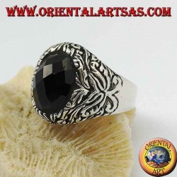 Anillo de plata con ónix facetado ovalado y decoraciones florales en alto relieve.