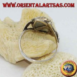 Silver ring with blue eye diagonally between two leaves