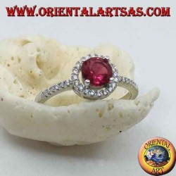 Silver ring with synthetic round ruby set surrounded by a row of zircons