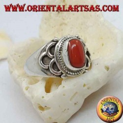 Anillo de plata con coral natural ovalado de origen tibetano antiguo con semicírculos en los lados.
