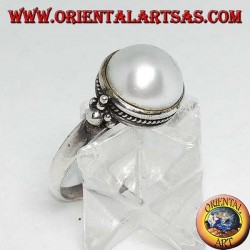 Anillo de plata con perla redonda rodeada de adornos trenzados y bolas a los lados.