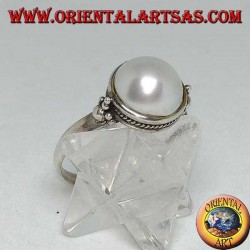 Silver ring with round pearl surrounded by braid decoration and balls on the sides