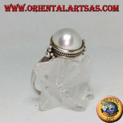 Silver ring with round pearl surrounded by braid decoration and balls on the sides
