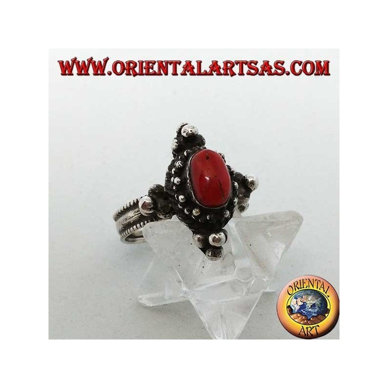Anello in argento con corallo ovale naturale su montatura tibetana con palline sui punti cardinali