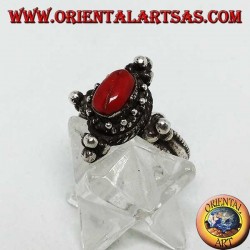 Anillo de plata con coral ovalado natural en un entorno tibetano con bolas en los puntos cardinales