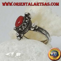 Anillo de plata con coral ovalado natural en un entorno tibetano con bolas en los puntos cardinales