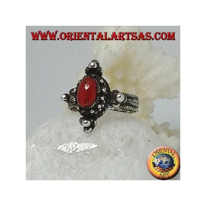 Anillo de plata con coral ovalado natural en un entorno tibetano con bolas en los puntos cardinales