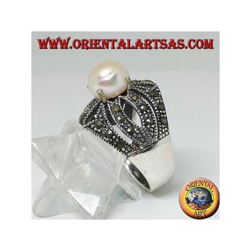 Bague en argent avec perle naturelle sertie sur une monture croisée ajourée parsemée de marcassite