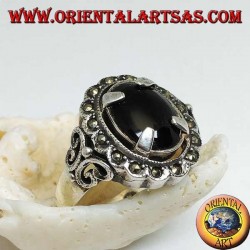 Anillo de plata con conjunto de ónix cabujón ovalado y rodeado de bolas de marcasita.