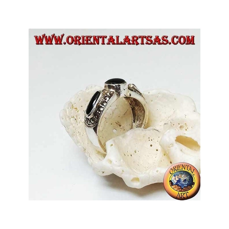 Anillo de plata con ónice redondo entre dos óvalos rodeados de marcasita.