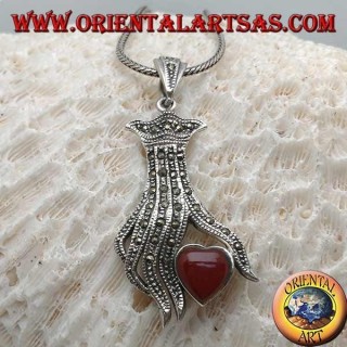 Ciondolo in argento, cuore in corniola tra le dita di una mano tempestata di marcassite