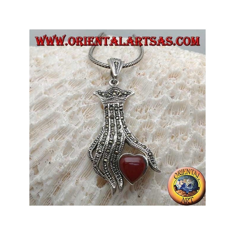 Silver pendant, carnelian heart between the fingers of a hand studded with marcasite