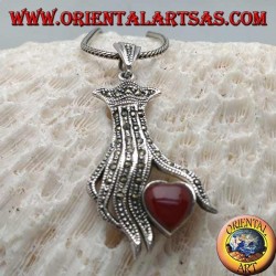 Colgante de plata, corazón de cornalina entre los dedos de una mano tachonada con marcasita