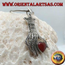 Colgante de plata, corazón de cornalina entre los dedos de una mano tachonada con marcasita