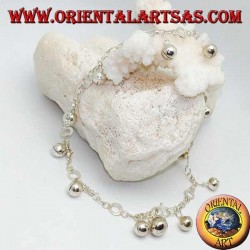 Tobillera plateada con campanas colgantes y discos alternos.