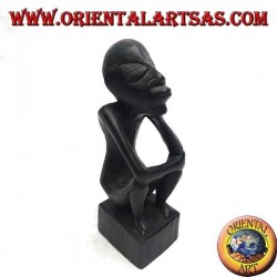 Escultura de un pensador sentado con las piernas dobladas en madera de ébano.