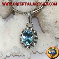 Silver pendant with oval and faceted natural blue topaz surrounded by rows of small and large balls