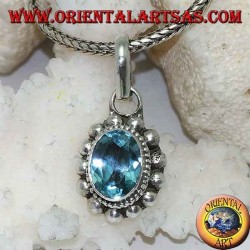 Silver pendant with oval and faceted natural blue topaz surrounded by rows of small and large balls