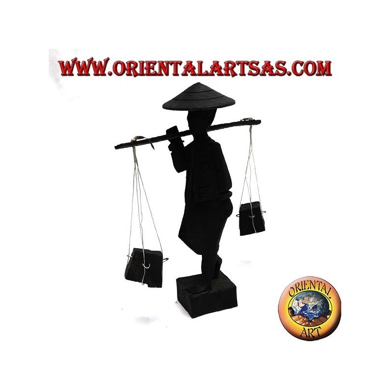Sculpture of an ancient courier with straw hat and stick with ebony wood goods on the shoulder