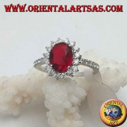 Silver ring with oval faceted garnet set and white zircons around and on the sides