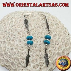 Silberne Ohrringe mit türkisfarbenen Scheiben und Kugeln zwischen zwei Federn