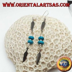 Pendientes colgantes de plata con discos de turquesa y bolas entre dos plumas.