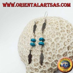 Pendientes colgantes de plata con discos de turquesa y bolas entre dos plumas.